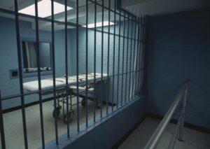 Image of a gurney behind prison bars; who are the executioners